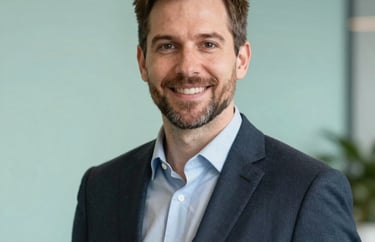 Professional headshot of a male program director in a clean, modern North American / Michigan US office. Deep Forest and Soft Mint background colors.