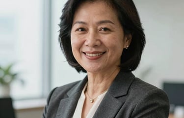 Professional portrait of a middle-aged Southeast Asian woman in business attire, smiling warmly in a bright office setting, photography.