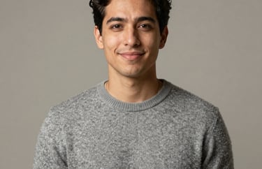 Portrait of a Spanish-speaking content creator in a neutral studio, wearing a soft warm grey sweater, smiling subtly, soft diffused light.