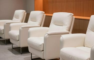 Photography of a modern recovery lounge for athletes, featuring white leather chairs and orange lighting accents. Minimalist and professional.