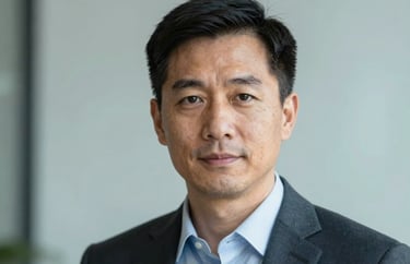 A headshot of a professional executive in business attire against a soft-focus muted light blue background, North American / US corporate style.