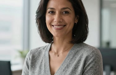 Portrait of a North American professional woman with a welcoming expression, wearing a smart gray cardigan, bright natural office light, professional photography.
