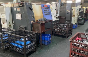 Industrial CNC lathe machines in a factory workshop producing precision metal components and parts.