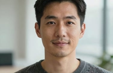 Professional headshot of a male clinical psychologist, calm and friendly expression, wearing a sweater, bright interior background.