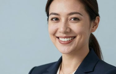 Professional headshot of a female counselor with a warm smile, wearing a professional blazer, soft studio lighting with a light blue background.