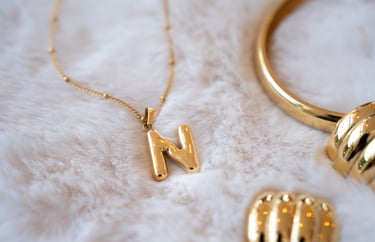 a gold necklace with a gold necklace with a letter m