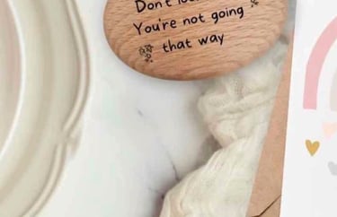 A wooden positivity pebble on a table with a positive card