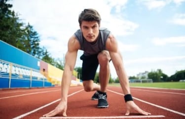 homme sportif de face mains au sol sur 1 piste au départ d''1 course de vitesse