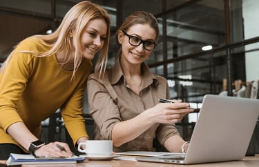 Deux professionnelles en train d'échanger et de consulter des ressources sur un ordinateur