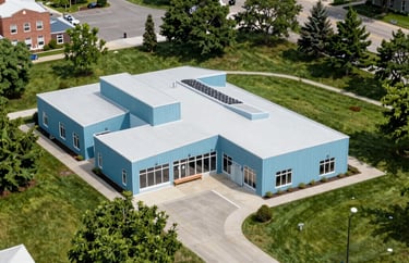 An aerial view of a vibrant, clean community center in a North American town, surrounded by green spaces and featuring modern architectural lines in light blue.