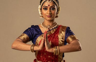 Professional studio portrait of a female South Asian / Indian classical dancer in traditional bharatanatyam attire, holding a graceful mudra, soft warm beige lighting, premium artistic style.