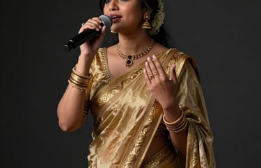 Professional studio portrait of a female South Asian / Indian vocalist in an elegant gold-bordered sari, expressing a raga, moody charcoal black background, luxurious artistic lighting.