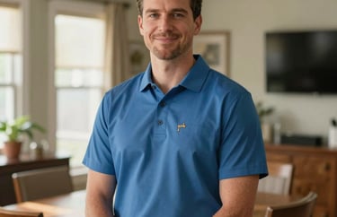 Portrait of a clinical staff member in a professional polo shirt, standing in a sunny, North American home dining room, looking trustworthy and kind.