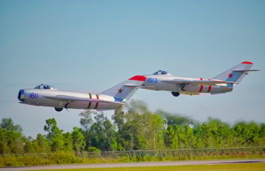 Two vintage Mikoyan-Gurevich MiG-17 fighter jets flying in close formation - Ft. Myers airshow