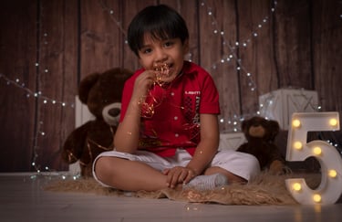 a young boy sitting on a rug with a teddy bear