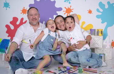 a family posing for a photo in front of a wall with paint splatters