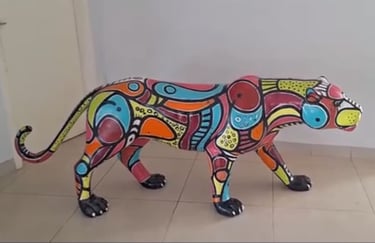 Detalhe da escultura de onça pintada com padrões gráficos vibrantes por Aloísio Marinho