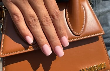 a woman's hands with a brown leather handbag
