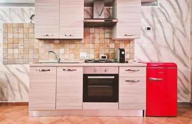 Cucina del monolocale con piano cottura, forno e arredi moderni