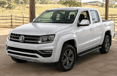 Amarok 4x4 diesel branca em showroom rural com campo ao fundo.