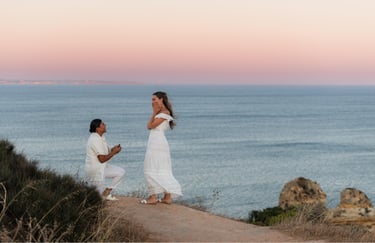 a woman proposing a woman on a cliff overlooking the ocean