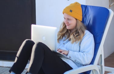 a woman sitting in a chair with a laptop on her lap