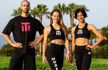 three people standing in front of a body of water