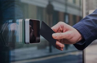 User tapping a proximity access card on a card reader at a secured building entrance