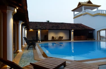 a pool with chairs and a clock tower