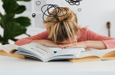 Person exhausted on books, symbolizing the struggles of learning without an immersive method