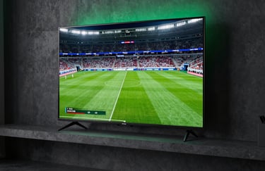 Straight-on shot of a modern, ultra-slim television mounted on a dark concrete wall in a dimly lit living room, glowing with a vibrant sports broadcast, high contrast, green stadium lighting casting a soft neon halo on the wall.