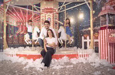 a family posing for a photo in front of a carousel