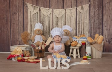 a baby in a chef hat and a teddy bear
