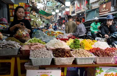 A Vietnamese woman working as a saleswoman together with a customer on his motorcycle at a street sh