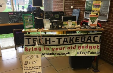 Our first pop-up collection: a home-made banner hangs from a table full of old tech