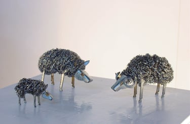 a group of steel wool metal sheep sculptures of various sizes