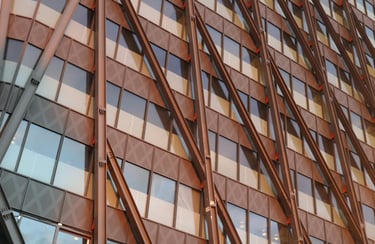 Fachada de edifício moderno com estrutura metálica aparente em diagonal e janelas de vidro