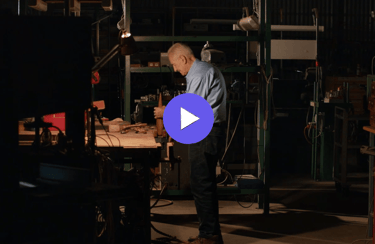 an man in a work shop with a blue shirt