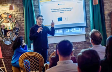 A man leading a corporate workshop presentation about program stakeholders to a seated audience.