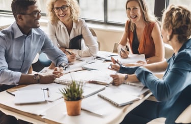 three men laughing while looking in the laptop inside room