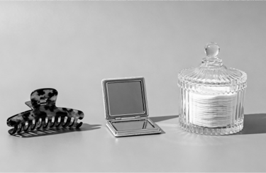 A minimalist set of daily essentials: hair clips, pocket mirror, and cotton pads.