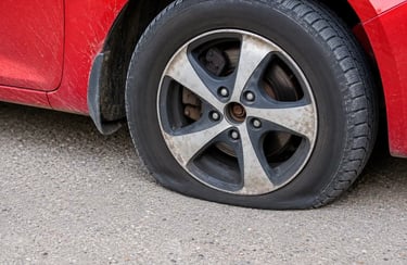Pneu murcho em veículo estacionado mostrando perda severa de pressão