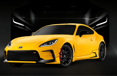 Toyota GR GT amarelo com visual esportivo agressivo e superesportivo V8 ao fundo em cenário escuro.