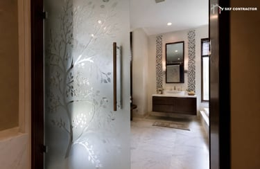 Modern bathroom design featuring a frosted glass door with tree etching and a floating vanity.
