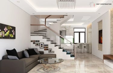 Modern open-concept living room with a dark grey sectional sofa and a sleek white staircase with glass railings.