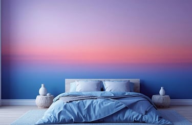 Modern bedroom with a blue bed and a sunset-inspired ombre wall mural in purple, pink, and blue.