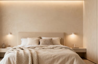 Minimalist modern bedroom interior with neutral beige linen bedding and warm ambient cove lighting.