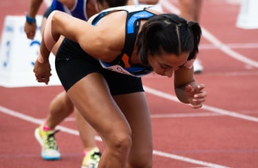 a woman in a blue and white outfit is running on a track