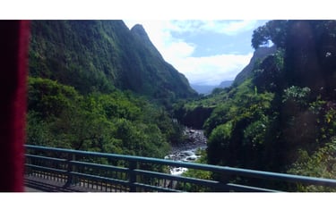 Estrada para Hell-Bourg vista da ponte, com cachoeiras e montanhas verdes na Ilha Reunião.