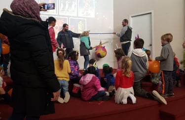 a group of children and adults celebrating birthday hitting a pinata